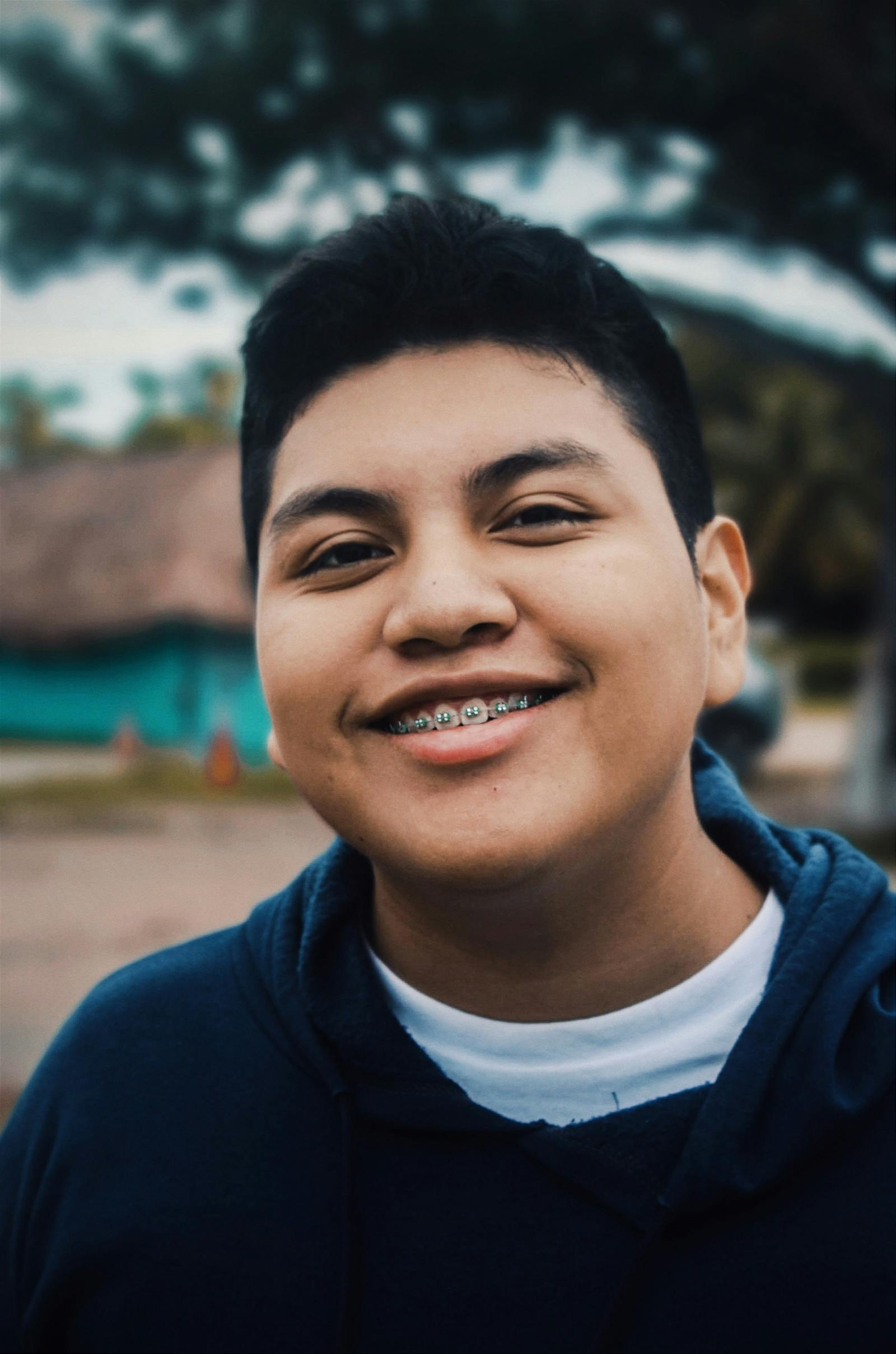 Jovem sorrindo com aparelho ortodôntico